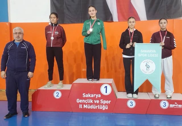 Yüksek seviyeli spor müsabakası, genç sporcular yarışıyor, ödüllü kupalar ve madalyalar kazanılıyor.