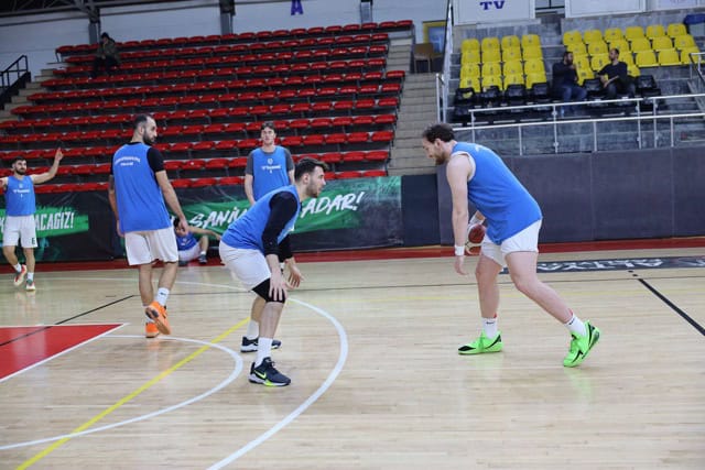 Salonda basketbol antrenmanı yapan oyuncular.